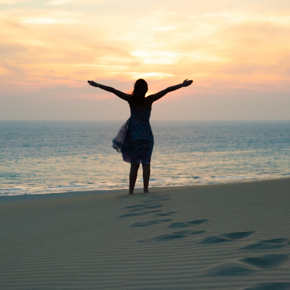 Anxiety free woman walking on beach Woman walking on beach after hypnotherapy in Sydney
