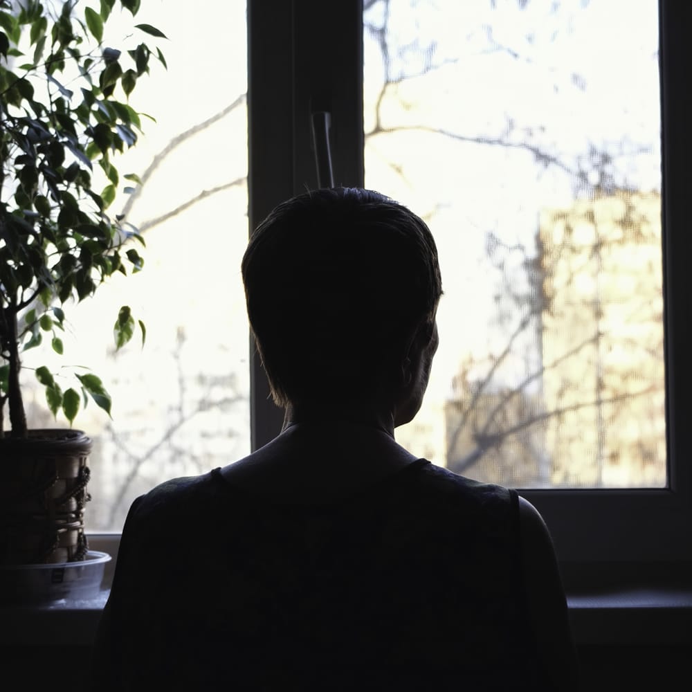 Woman with depression looking outside window Woman with depression looking outside window