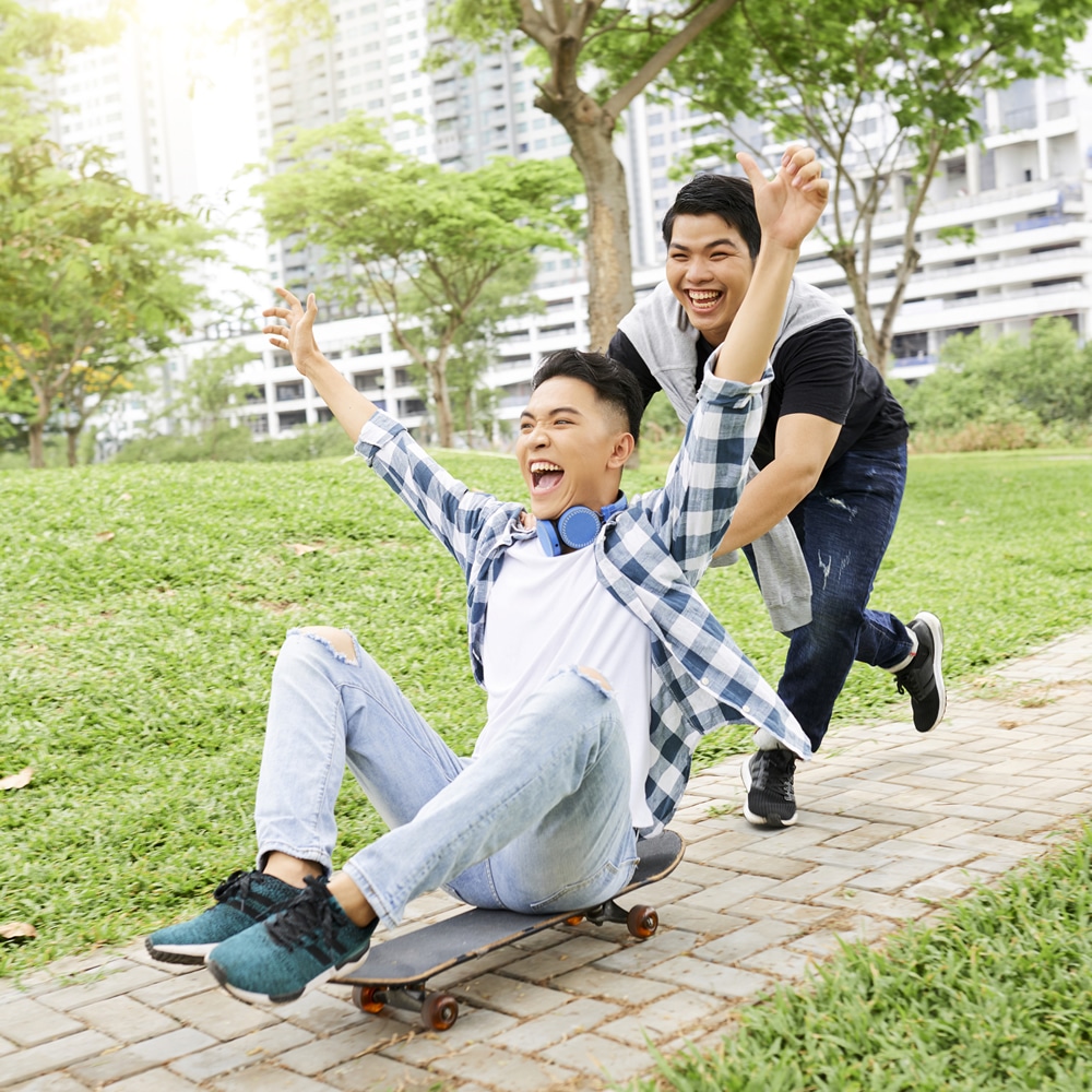 Smiling teenagers skateboarding Smiling teenagers skateboarding in park