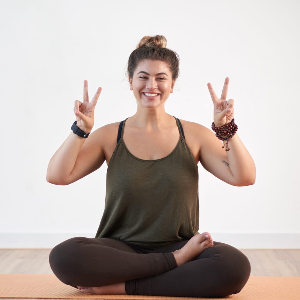 Yoga woman smiling after hypnotherapy Yoga woman smiling after hypnotherapy giving victory sign