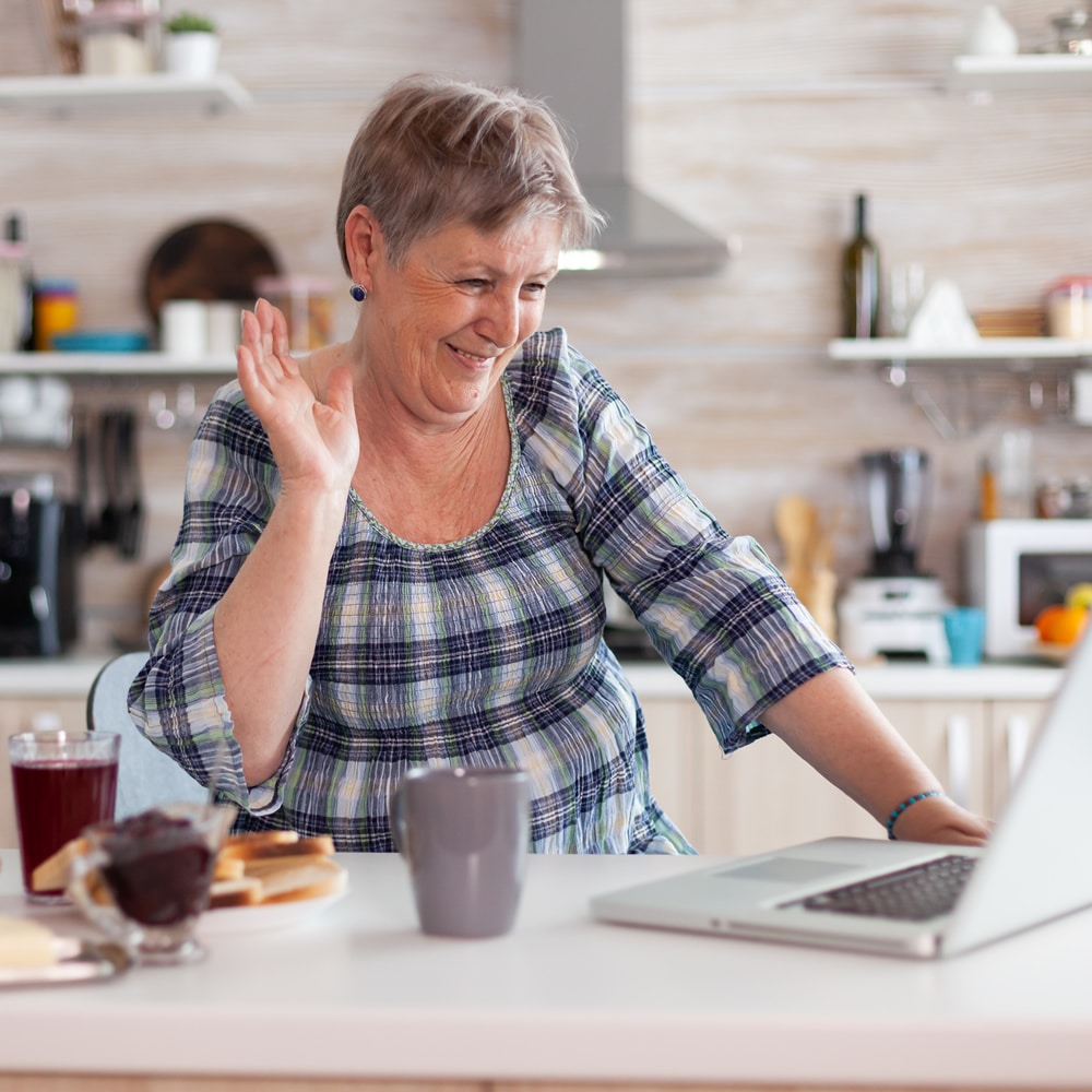 Woman waving during online hypnotherapy session