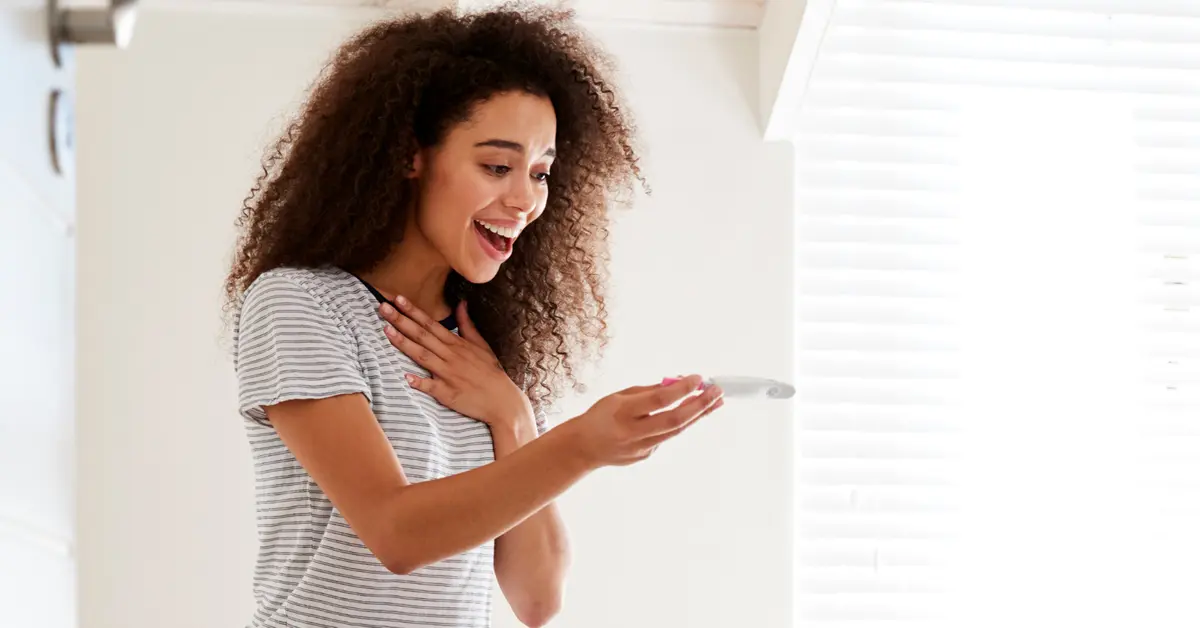 Woman with positive pregnancy test after hypnofertility Woman excited with positive pregnancy test after hypnofertility session