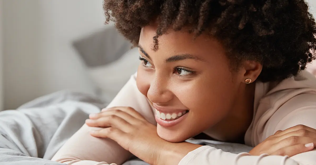 Woman relaxed and smiling after having hypnotherapy for anger management